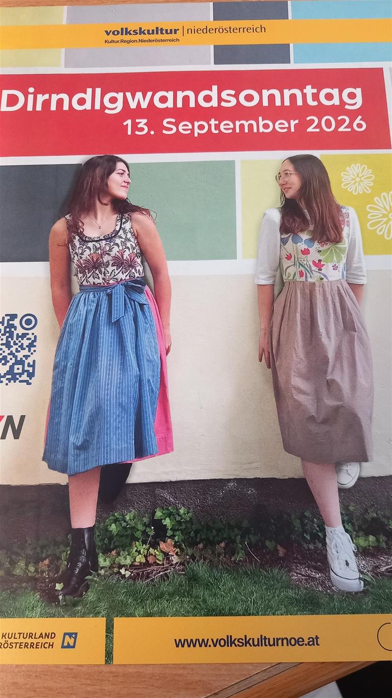 2 Frauen im Dirndl an eine Wand gelehnt - die sich ansehen