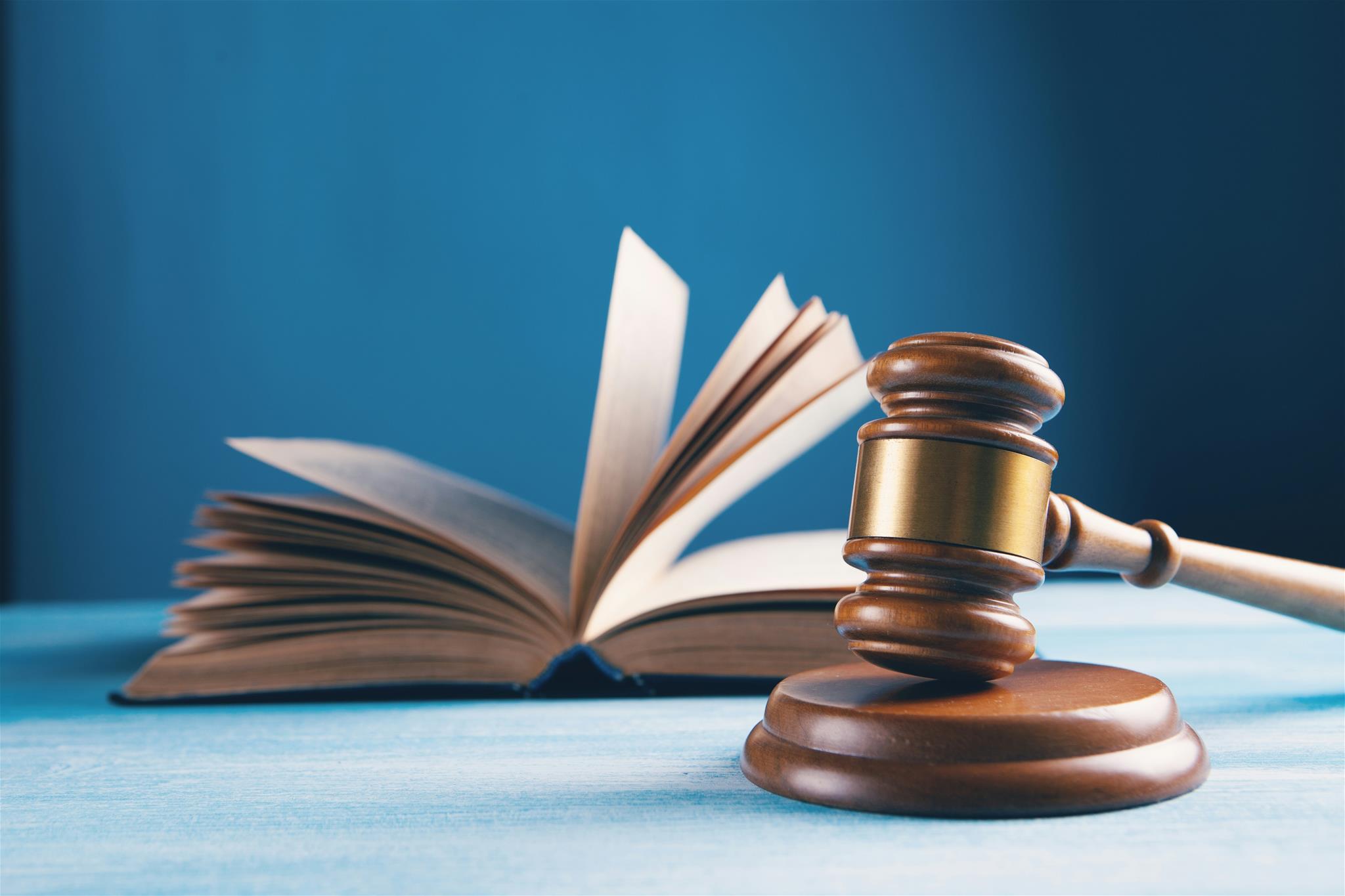 offenes Buch mit einem Hammer zur Urteilsverkündung